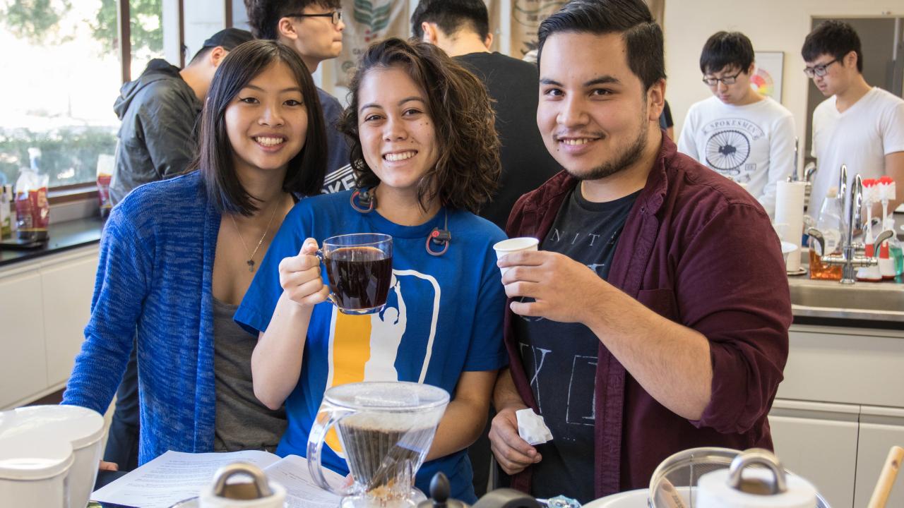 Students hold coffee cups in lab