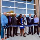 Seven people stand in front of the coffee center at a ribbon cutting ceremony