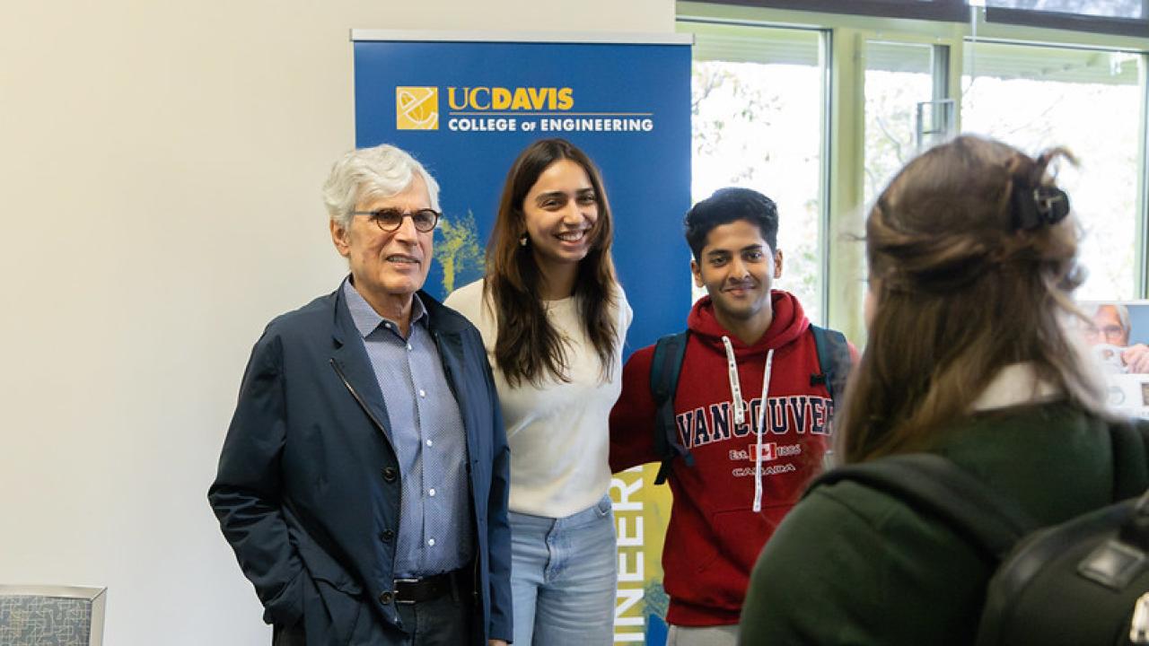 Jerry Baldwin stands with students in front of a College of Engineering banner